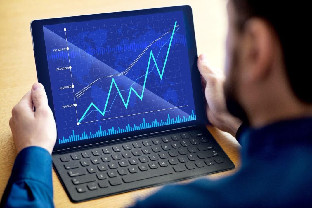 profissional analisa grafico de crescimento em tablet simbolizando regulacao de criptoativos e maturacao do mercado digital no brasil